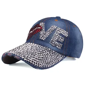 Detail of LOVE rhinestone patterns and worn-out effects on dark blue denim baseball cap