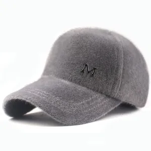Detailed close-up of gray plush baseball cap featuring a metallic M logo and soft fur texture