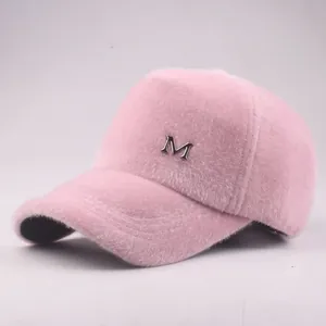 Close-up of pink plush baseball cap showing soft texture and silver metal M logo