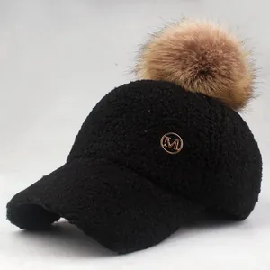 Detailed view of the soft teddy fleece texture and golden M logo on the black baseball cap