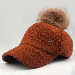Macro detail of caramel lamb wool texture and gold M logo on a winter baseball cap