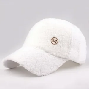 Detail of white sherpa fleece texture and round metal M logo on the winter baseball cap
