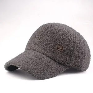 Detail of grey fleece baseball cap featuring a golden metallic M letter buckle