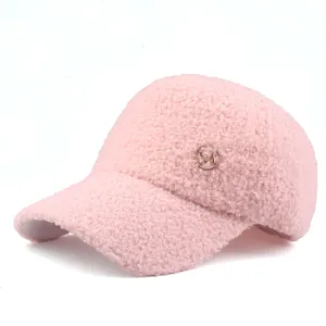 Close-up of pink faux shearling baseball cap with rose gold M letter metal logo