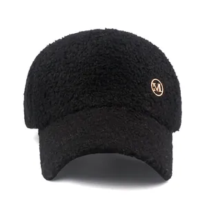 Black sherpa baseball cap with a gold M-logo metal badge on a clean white background
