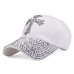 Dettaglio del berretto bianco con croce di strass e visiera decorata con diamanti lucidi