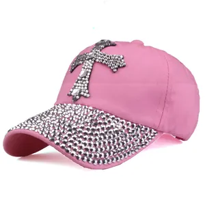 Dettaglio del cappello rosa con croce di strass argentati e decorazioni sulla visiera