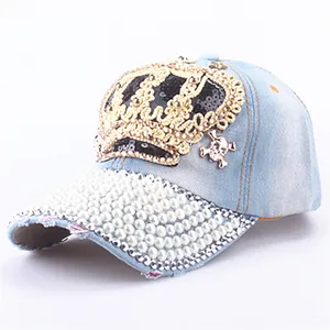 Detail of sequined crown and faux pearls on light blue washed denim baseball cap