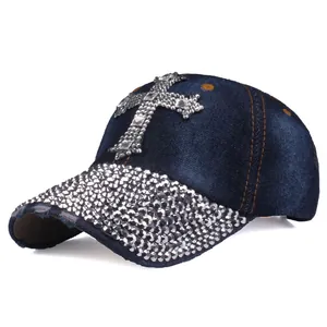 Dettaglio di strass argentati e croce su cappello da baseball in denim blu vintage