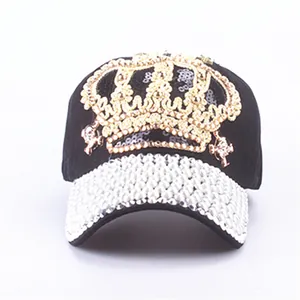 Detailed close-up of crown embroidery and rhinestones on black denim baseball cap