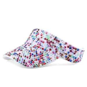 Detailweergave van witte zonnevizier met veelkleurige steentjes en glanzende afwerking