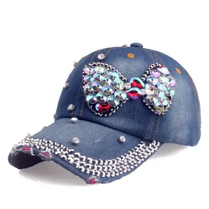 Detailed macro of a navy denim baseball cap featuring large crystal bow and studs