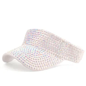 Detail van witte zonneklep met dichte iriserende strass-steentjes en glanzende afwerking