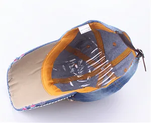 Detail view of denim baseball cap interior showing 100% cotton label and sweatband