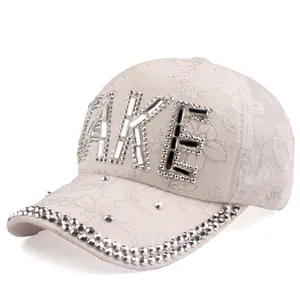 Close-up of white lace baseball cap featuring rhinestones and FAKE letter decoration