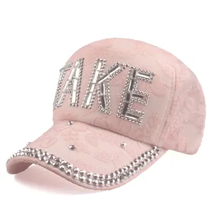 Detailed view of pink lace baseball cap featuring shimmering rhinestone TAKE lettering