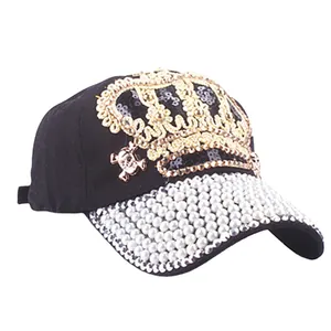 Denim baseball cap with gold crown embroidery, pearls and skull charm on black fabric