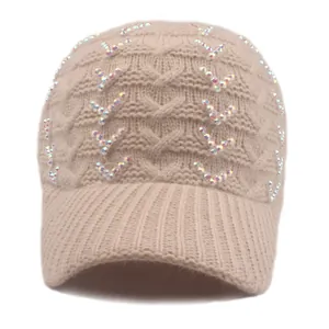Detailed knit texture of beige baseball cap with sparkling V-shaped rhinestone embellishments