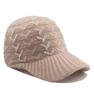 Close-up of beige cable knit baseball cap with iridescent rhinestone V-shape detail