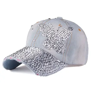 Dettaglio della farfalla di strass scintillanti su cappello di jeans azzurro denim