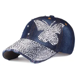 Dettaglio cappellino in denim lavato con farfalla di strass e borchie argentate