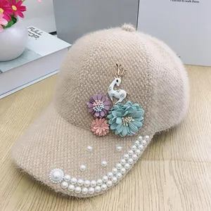 Détail d'une casquette beige en polaire avec fleurs 3D et perles sur la visière