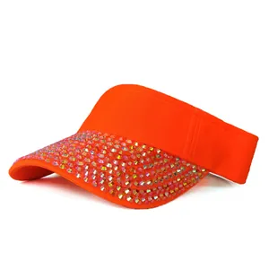 Detail of bright orange sun visor hat with sparkling colorful rhinestones on the brim