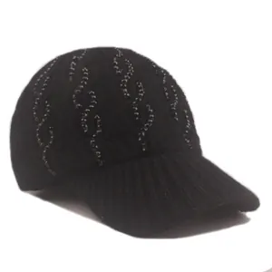 Detailed view of black knitted baseball cap with decorative beaded wave patterns