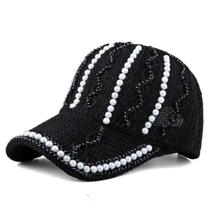 Détail de la casquette noire en maille avec perles blanches et strass étincelants