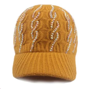 Macro detail of ginger yellow knit beanie with rhinestone embellishments and cable pattern