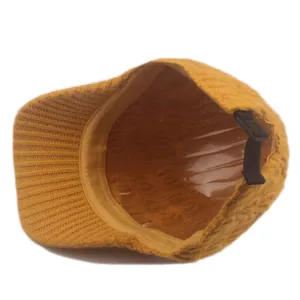 Detailed interior of ginger yellow knit baseball cap showing adjustable strap and texture