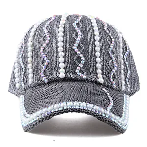 Détail de la casquette grise en maille ornée de strass brillants et de perles élégantes