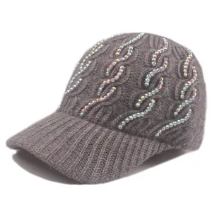 Detailed texture of cable knit wool hat with colorful rhinestones on a dark grey fabric