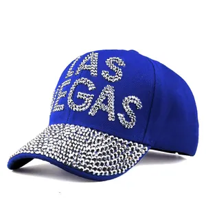 Close-up of sparkling rhinestone LAS VEGAS lettering on royal blue cotton baseball cap