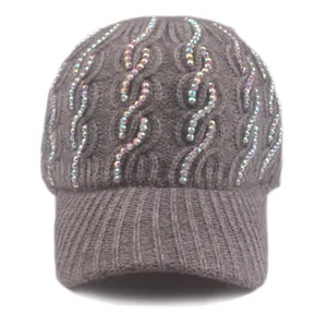 Detail of grey knitted baseball cap with sparkling rhinestones and cable knit texture