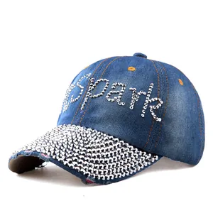 Dettaglio della scritta Spark in strass scintillanti su cappello di jeans blu