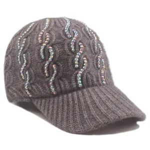 Detail of grey cable knit baseball cap featuring wave pattern iridescent rhinestones