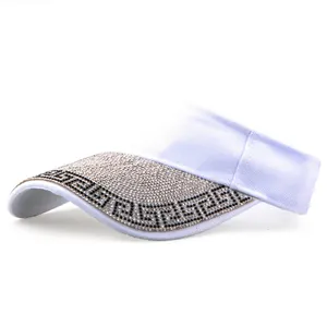 Detail of white sun visor featuring shimmering silver rhinestones and black Greca pattern