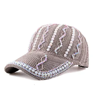 Détail de strass étincelants et perles blanches sur casquette de baseball en maille marron
