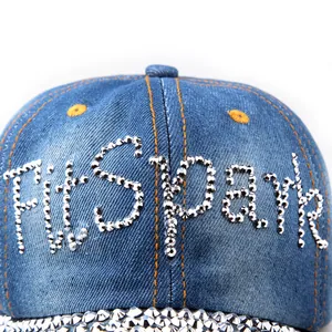 Dettaglio ravvicinato del cappellino in denim blu con scritte Fitspark in cristallo