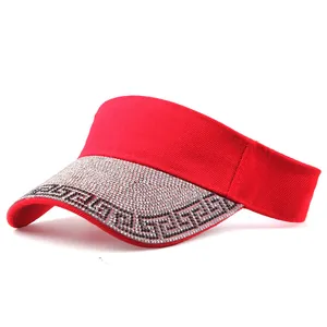 Detail of red sun visor brim with sparkling crystals and Greek key pattern