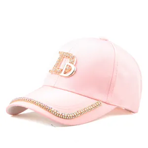 Détail d'une casquette rose avec logo en strass étincelant et bordure cristalline