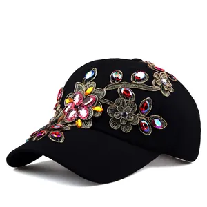 Detailed view of floral gold embroidery and colorful rhinestones on a black baseball cap