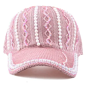 Gros plan sur casquette baseball en mesh rose avec perles blanches et strass brillants