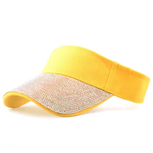 Close-up of bright yellow sun visor hat with sparkling rhinestones on the brim
