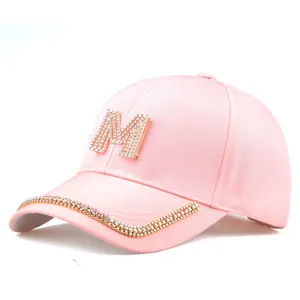 Detailansicht der rosa Baseballkappe mit funkelndem M-Buchstaben und Strasssteinen