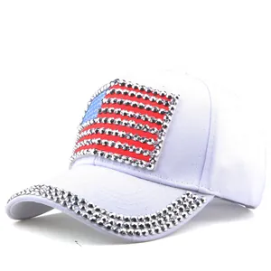 Detail of white baseball cap featuring rhinestone USA flag and sparkling brim decoration