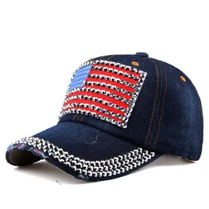 Close-up of rhinestone American flag design and crystal studs on navy denim baseball cap