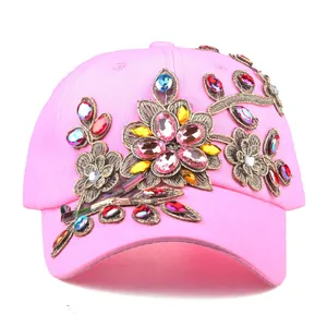 Close-up of pink baseball cap featuring colorful rhinestone-studded floral embroidery detail