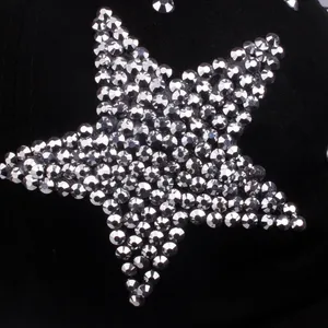 Detailed view of silver rhinestone star pattern on black fabric baseball cap surface